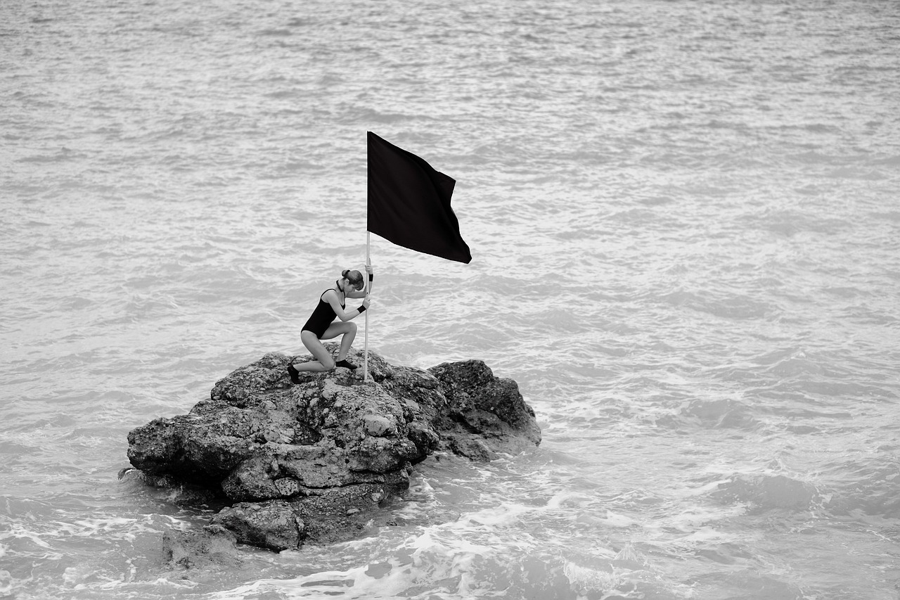 femme qui plante drapeau au milieu de l'eau